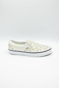 A single Vans slip-on platform sneaker in off-white and beige checkerboard canvas with metal studs on the toe, set against a plain white studio background.
