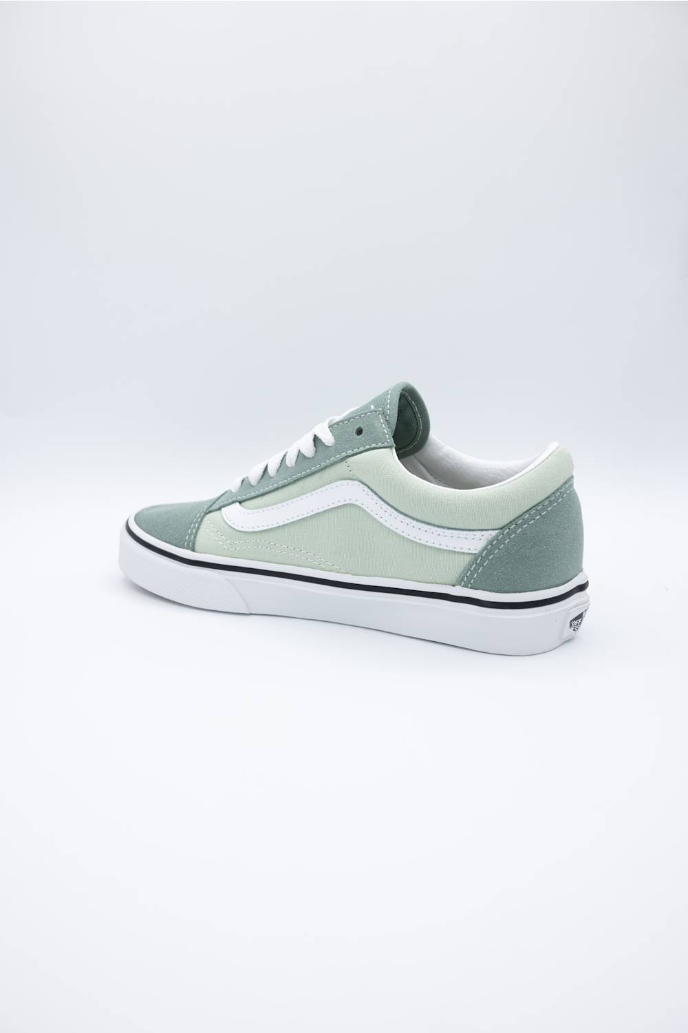 A single Vans Old Skool sneaker in a muted sage green colorway, featuring a white side stripe, white laces, and a white rubber sole, photographed from a side profile against a clean white studio background.