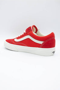 A red Vans Old Skool sneaker with a white side stripe and white sole, shown from a three-quarters angle on a light gray background.