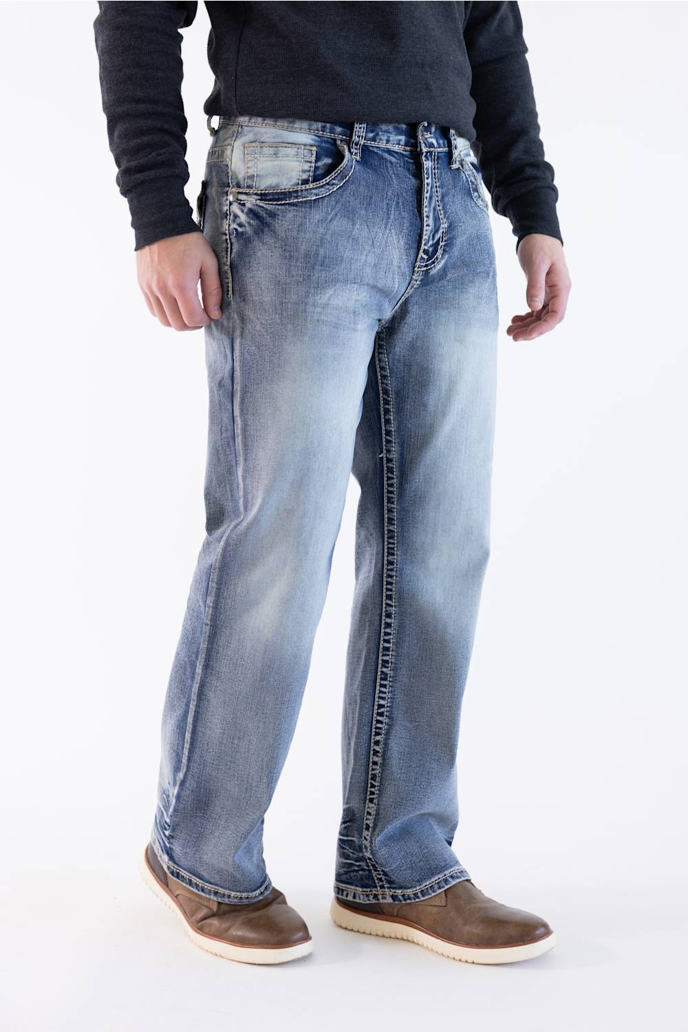 Side profile view of a model wearing True Luck Weller loose straight jeans with fading, styled with a dark long-sleeve shirt and brown shoes.
