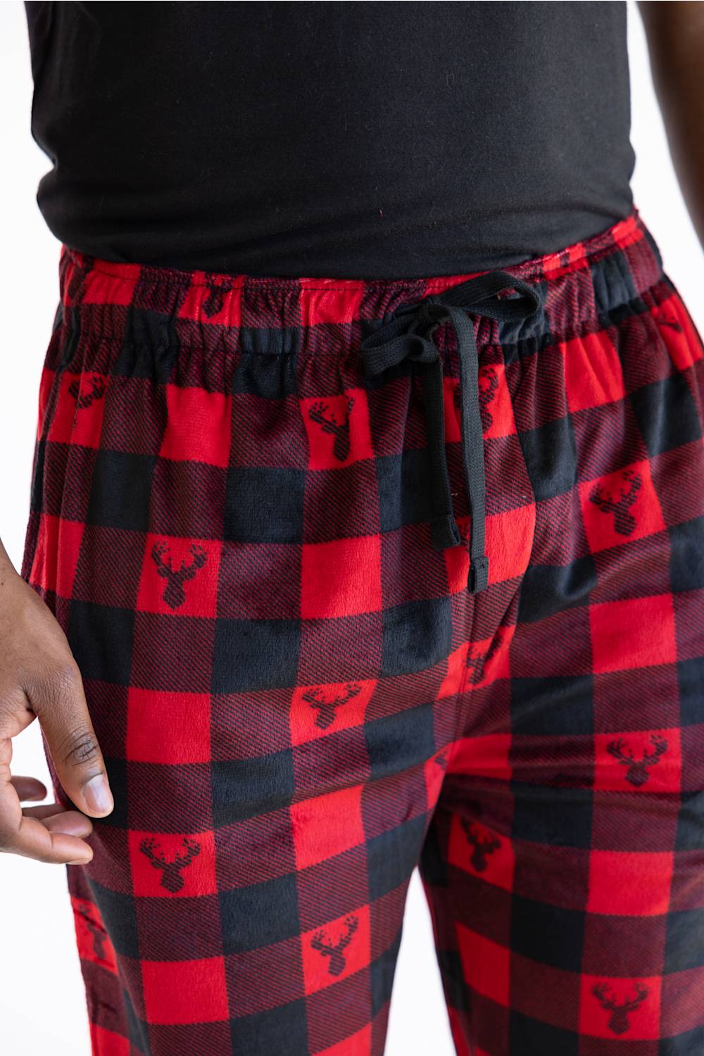 Red and black buffalo plaid pajama pants with a small black deer head logo printed in each check, shown on a model wearing a black shirt.