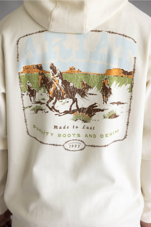 Close-up of the back of an off-white hoodie featuring a large vintage-style western graphic print with barbed wire, cowboys on horseback, and text reading 'Made to Last Quality Boots and Denim' and 'Since 1993'.