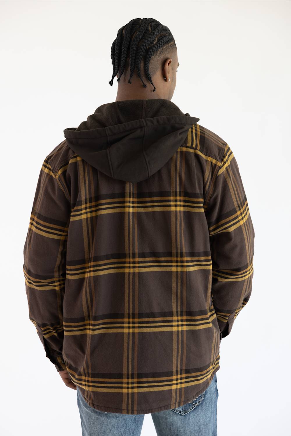 A man viewed from behind wearing a brown hooded jacket with a yellow and black plaid pattern, paired with blue jeans, against a plain white background.
