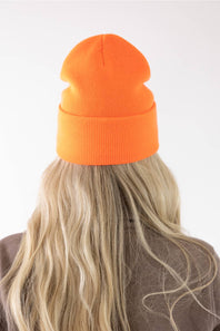 back view of a blonde woman modeling a orange Carhartt beanie 