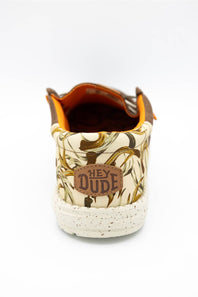 A single low-top sneaker shown from the back on a white background, featuring a cream and brown abstract patterned canvas upper, a brown leather patch with 'HEY DUDE' text, and a speckled off-white rubber sole.