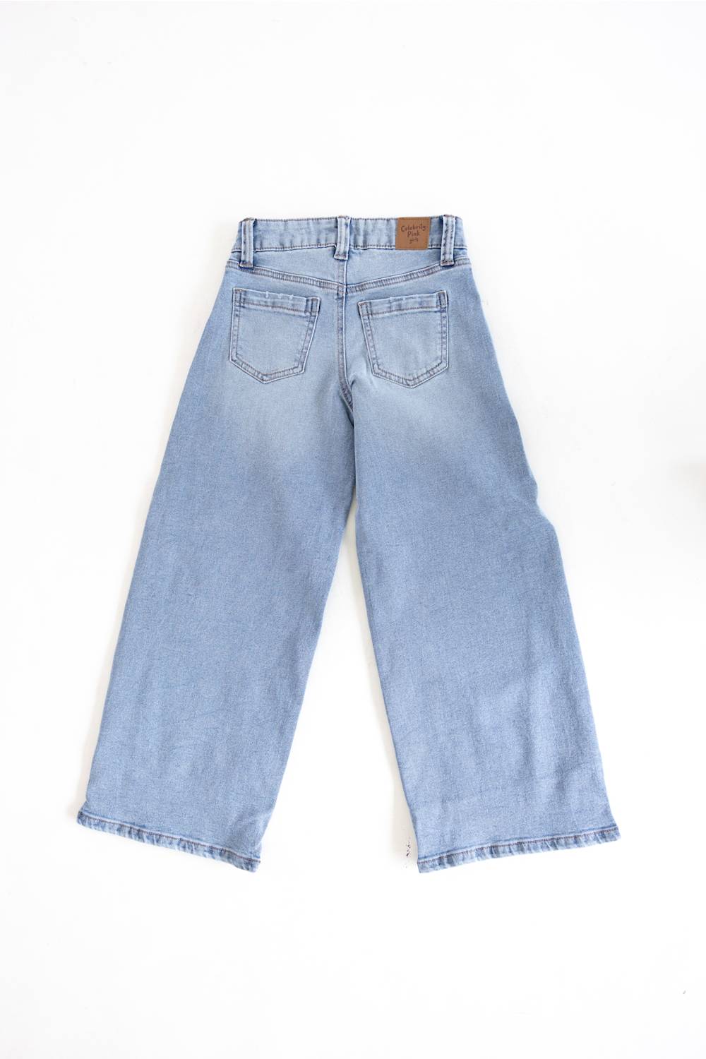 Light blue denim cropped pants shown from the back, featuring a straight-leg fit, back pockets, and a small brown leather brand patch at the waistband, laid flat on a white background.