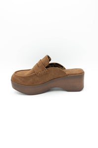 A single brown suede mule clog with a chunky platform sole, shown from a side profile view against a plain white background.