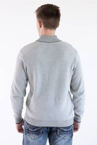 Rear view of a male model wearing the platinum gray F/X Fusion birdseye knit quarter-zip pullover, paired with blue jeans.