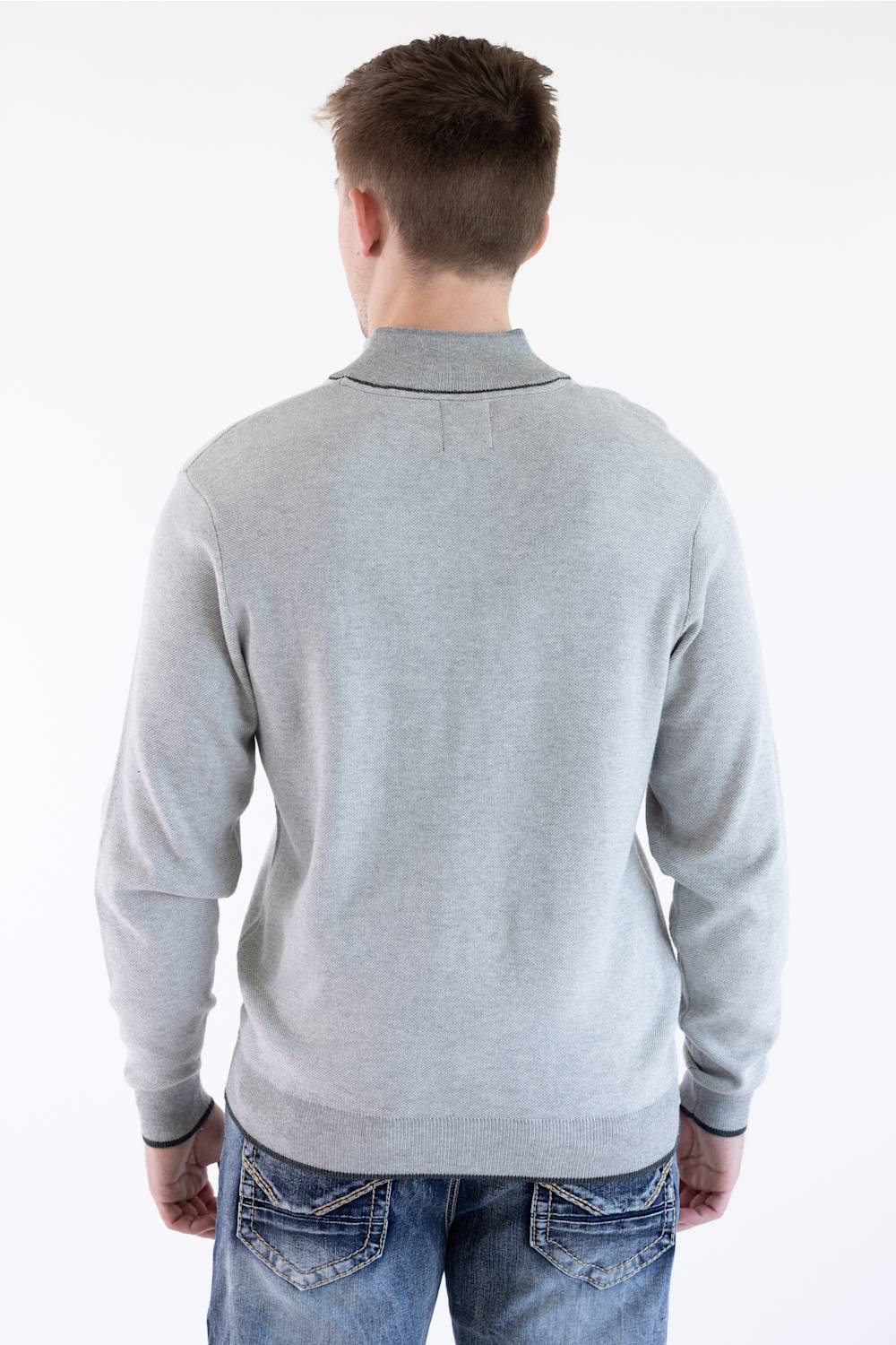 Rear view of a male model wearing the platinum gray F/X Fusion birdseye knit quarter-zip pullover, paired with blue jeans.