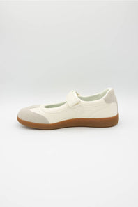 A single Mary Jane shoe in off-white and light beige with a brown gum sole, shown in profile against a light gray background.