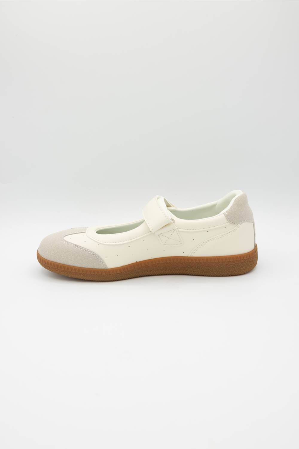 A single Mary Jane shoe in off-white and light beige with a brown gum sole, shown in profile against a light gray background.