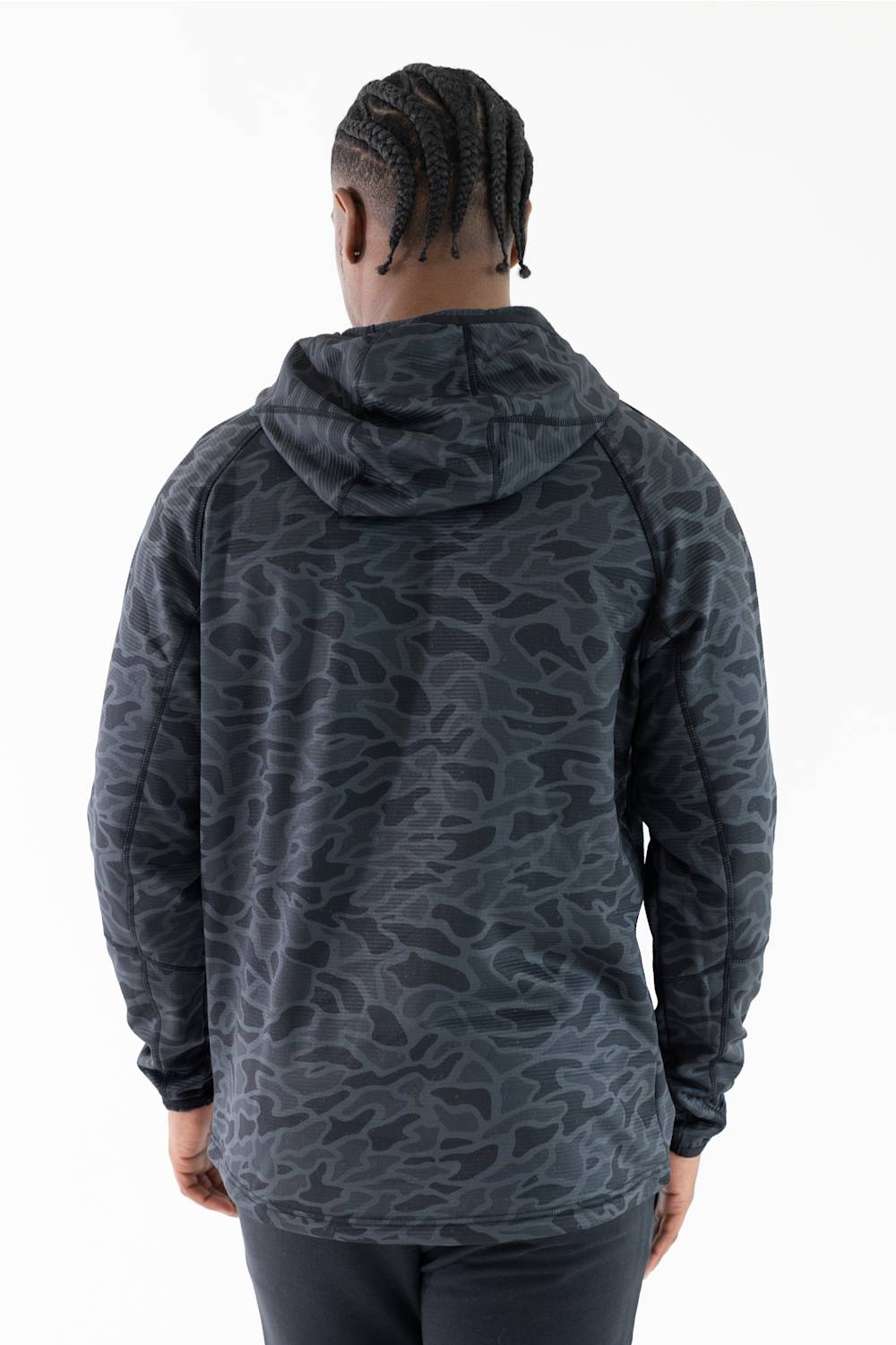 A man viewed from behind wearing a dark gray and black camouflage-patterned hooded sweatshirt against a plain white background.