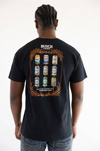A detailed photograph of the back of a male model with a braided hairstyle, wearing the black Busch Light Can Evolution T-Shirt. The shirt features a large graphic design on the back including nine vintage Busch Light hunting cans arranged chronologically from 2015 to 2026, framed by an orange antler design, and the text 'EVOLUTION OF BUSCH LIGHT HUNTING CAN'.
