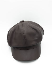A dark chocolate brown faux leather newsboy hat featuring a classic 8-panel design, a soft curved brim, and a top button, displayed against a solid white background.