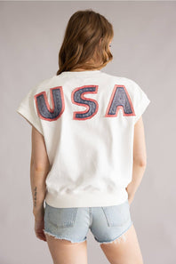 Person wearing a white t-shirt with 'USA' printed on the back against a plain background