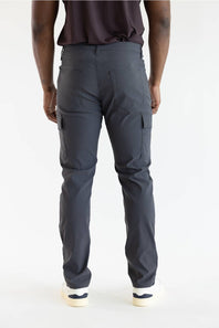 Rear view of a person wearing dark charcoal cargo pants with a dark brown top and white sneakers, photographed against a clean white studio background.