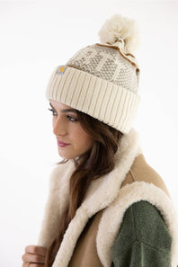 Model wearing a Carhartt thick knit cuffed beanie with a pom-pom in Oat Milk