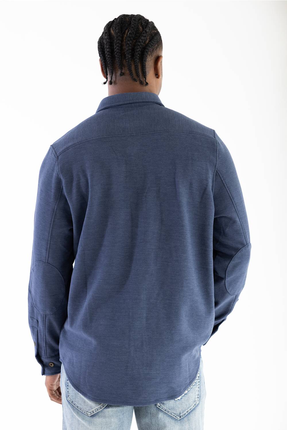 A man viewed from behind wearing a navy blue long-sleeve button-up shirt and light wash jeans against a plain white background.