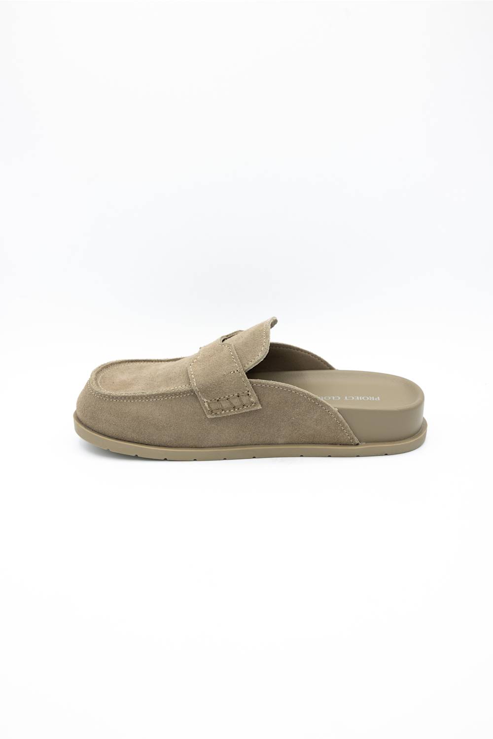 A single taupe-brown slip-on mule shoe with a suede-like upper and a small decorative strap detail on the side, shown from a side profile against a white background.