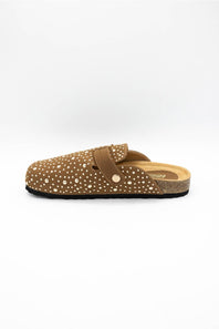 A single brown clog-style mule shoe with white polka dots, a brown strap with a gold-tone button, and a cork-textured midsole, shown against a plain white background.