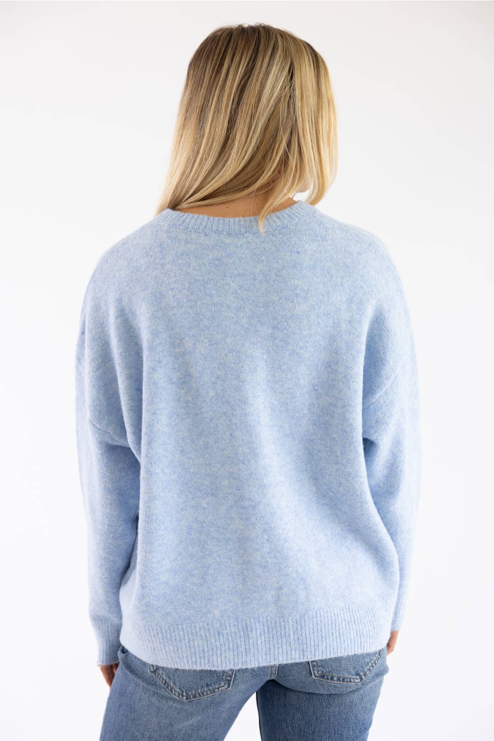 back view of a blonde woman modeling a periwinkle sweater 