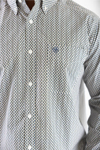 Close-up of a men's long-sleeve button-down shirt with a small-scale geometric pattern in gray and white, featuring white buttons and a small embroidered logo on the left chest.