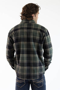 A man viewed from behind wearing a dark green and black plaid flannel shirt jacket with blue jeans, set against a plain white background.