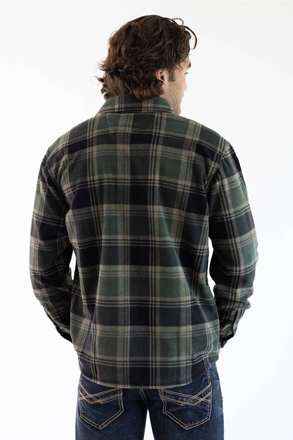 A man viewed from behind wearing a dark green and black plaid flannel shirt jacket with blue jeans, set against a plain white background.