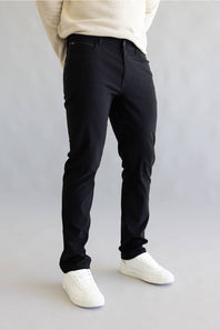 Man wearing black pants and white shoes on a plain background