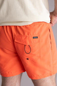 Orange swim shorts with a Quiksilver brand logo on a neutral background