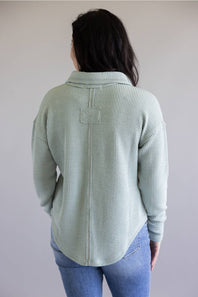 Ribbed v-neck sweater with long sleeves and exposed seams in light teal
