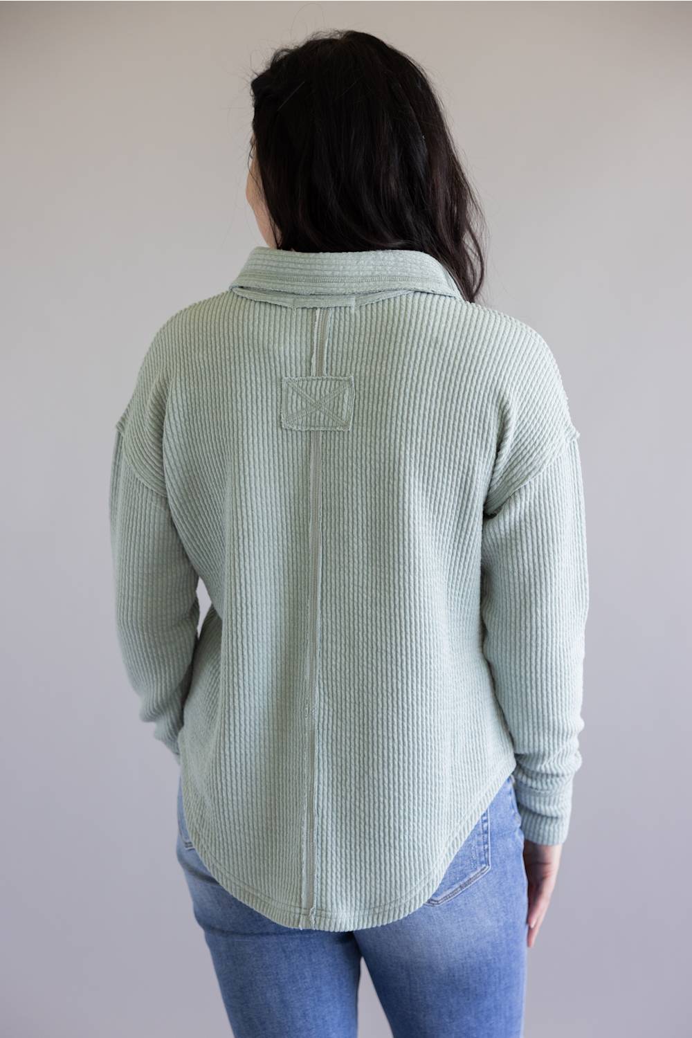 Ribbed v-neck sweater with long sleeves and exposed seams in light teal