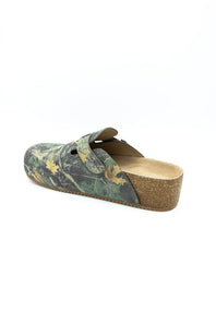 A single clog-style mule shoe with a green and brown leafy camouflage pattern upper, a cork wedge heel, and a tan insole, shown from a side angle on a white background.