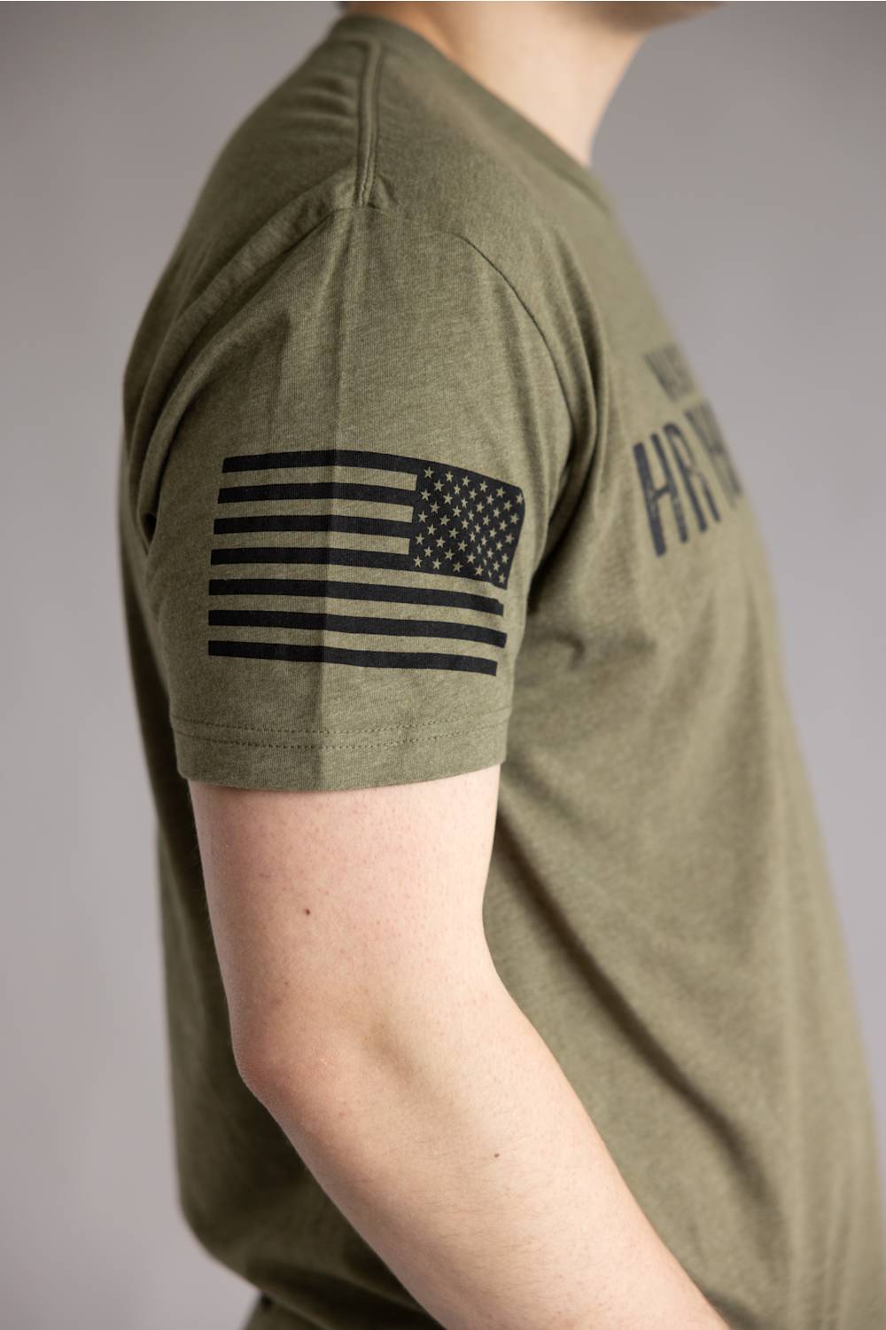 Grunt Style 1776 HR Nightmare T-Shirt for Men in Green; Person wearing a green t-shirt with an American flag patch on a gray background