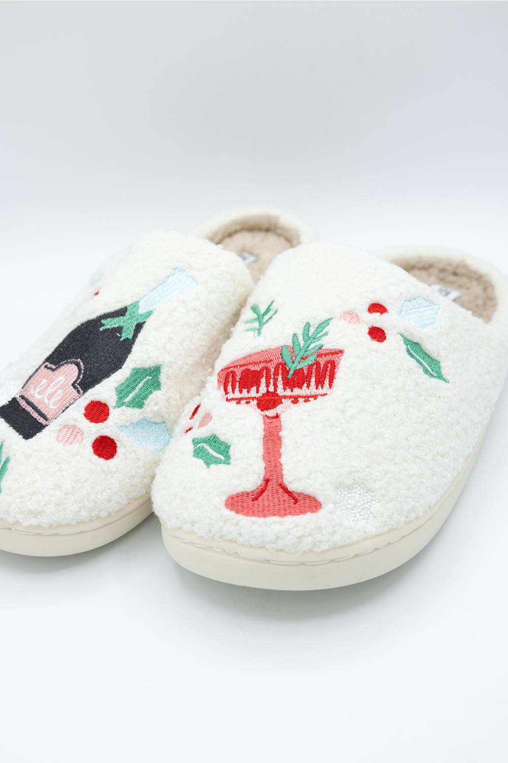 close up of a white fuzzy slipper featuring festive holiday drinks