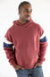 A man wearing a dusty rose red pullover hoodie with navy blue and white stripes on the sleeves, paired with blue jeans, against a plain white background.
