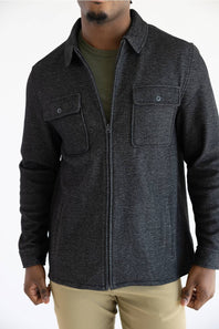 A man wearing a Hallstatt full zip Knit Jacket for Men in Charcoal Grey with two chest pockets.