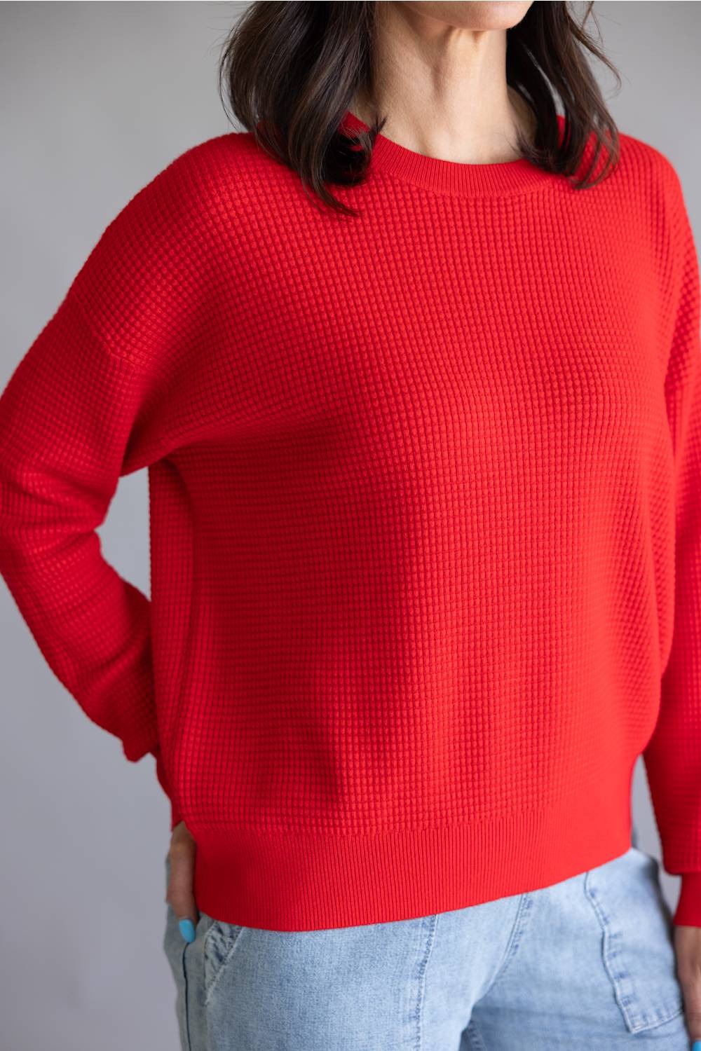 Waffle textured sweater top in a vibrant red color, with thick hems and cuffs 