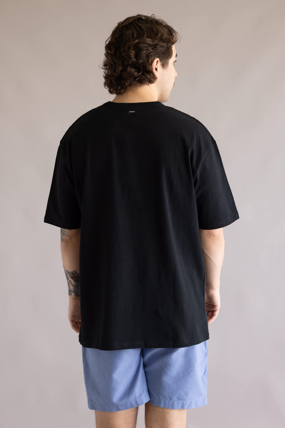 Industrie Del Sur T-Shirt for Men in Black; Person wearing a black t-shirt and blue shorts against a plain background