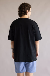 Industrie Del Sur T-Shirt for Men in Black; Person wearing a black t-shirt and blue shorts against a plain background