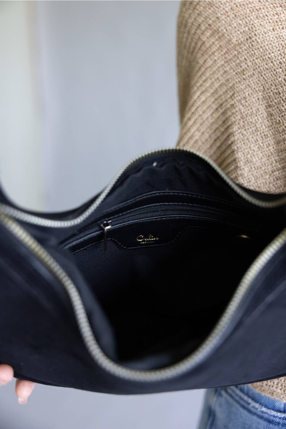 Crescent shaped faux suede shoulder bag with an adjustable buckle detail on strap