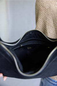 Crescent shaped faux suede shoulder bag with an adjustable buckle detail on strap