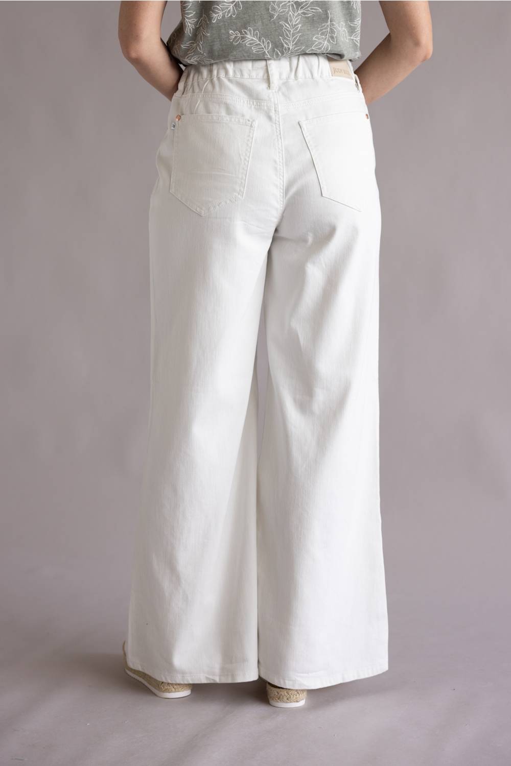 Judy Blue White Featherweight Palazzo Jeans for Women in White; White wide-leg pants worn by a person on a plain background
