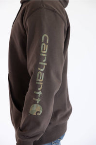 Side-profile close-up view of the left arm and torso of a male model against a plain white background, wearing a dark clove brown Carhartt hooded sweatshirt featuring "carhartt" printed vertically down the sleeve alongside the Carhartt logo emblem.