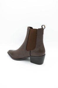 A dark brown leather ankle boot with a dark brown elastic side panel and a low black block heel, shown from a side-rear angle on a white background.