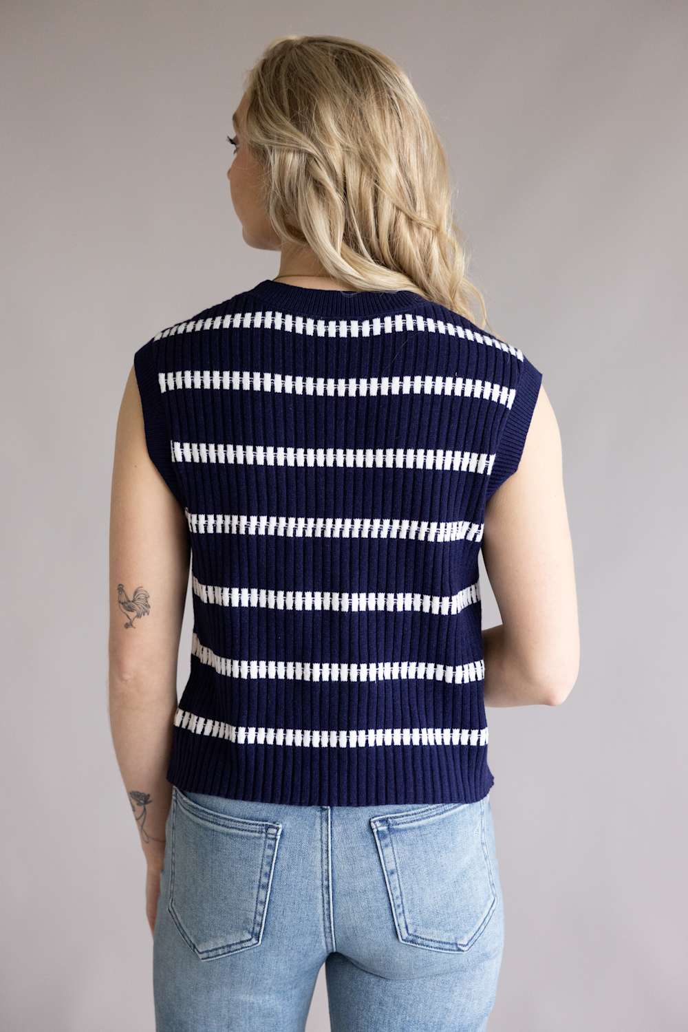 Person showing the back of the La Miel Crochet Stripe Top for Women in Galaxy, a striped sleeves knit sweater in navy and white
