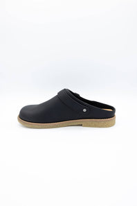 A single black leather clog shoe with a tan cork-look sole, shown in profile against a plain white background.