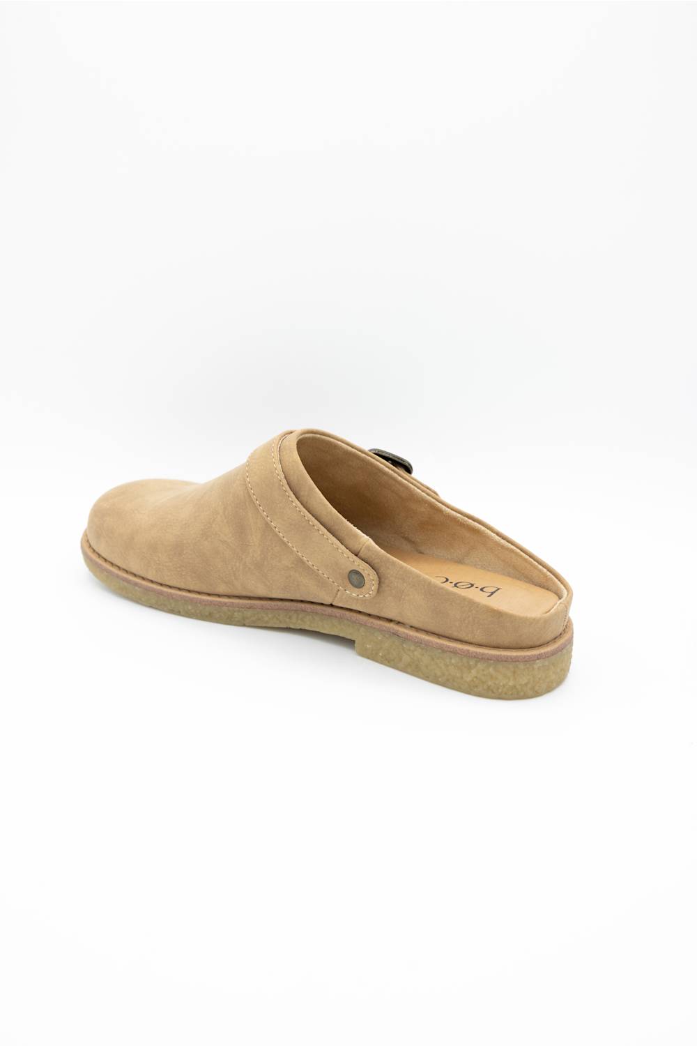 A tan suede clog-style mule shoe with a low tan sole, shown from a side-rear angle on a white background.