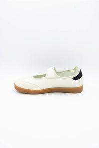 A single white slip-on shoe with a tan gum sole and a small black heel tab, shown from the side on a white background.