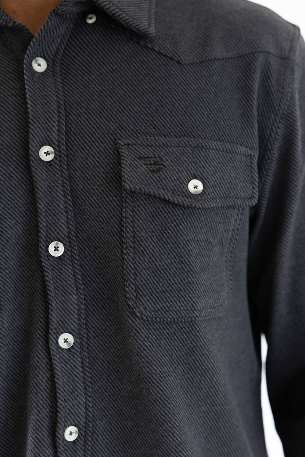 Close-up of a dark charcoal gray textured button-down shirt with a chest pocket and silver buttons.